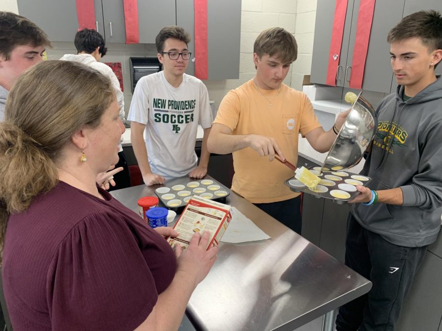 Mrs. DeLuca instructs her students while they attempt to make cupcakes. 