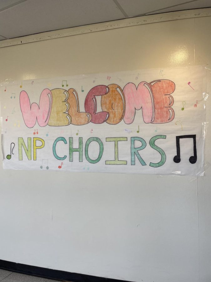 A colorful banner outside the auditorium welcomes members of the chorus. 
