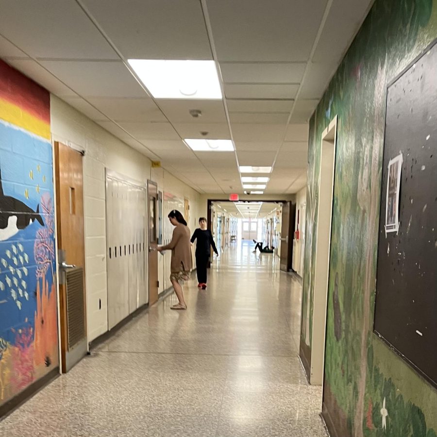 A teacher walking to a class to borrow materials for her students.