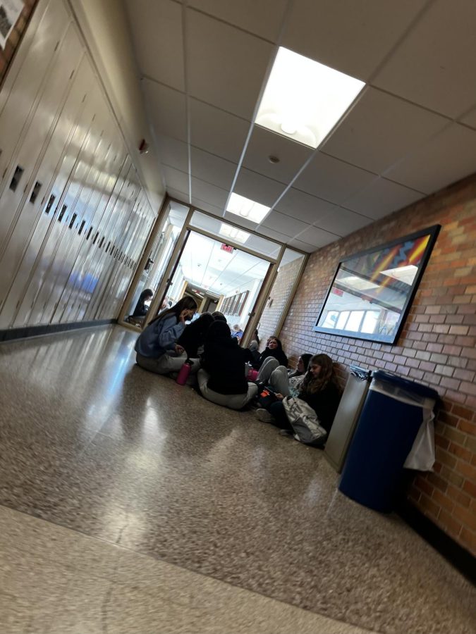 Students during lunch in glass hallway from different point of view.