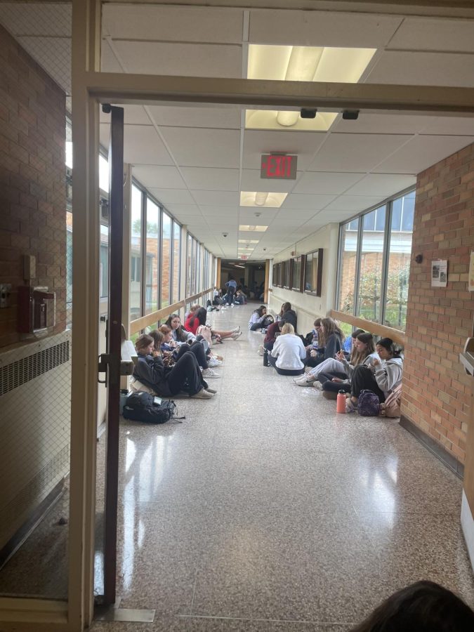 Tons of students like to sit in the hallway and eat with their friends. 
