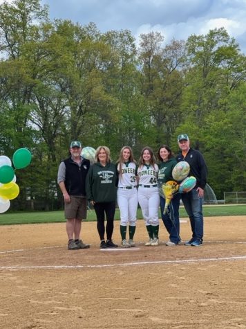 Seniors Abby Miller and Olivia Mulqueen from the New Providence High School Softball team standing with their parents.