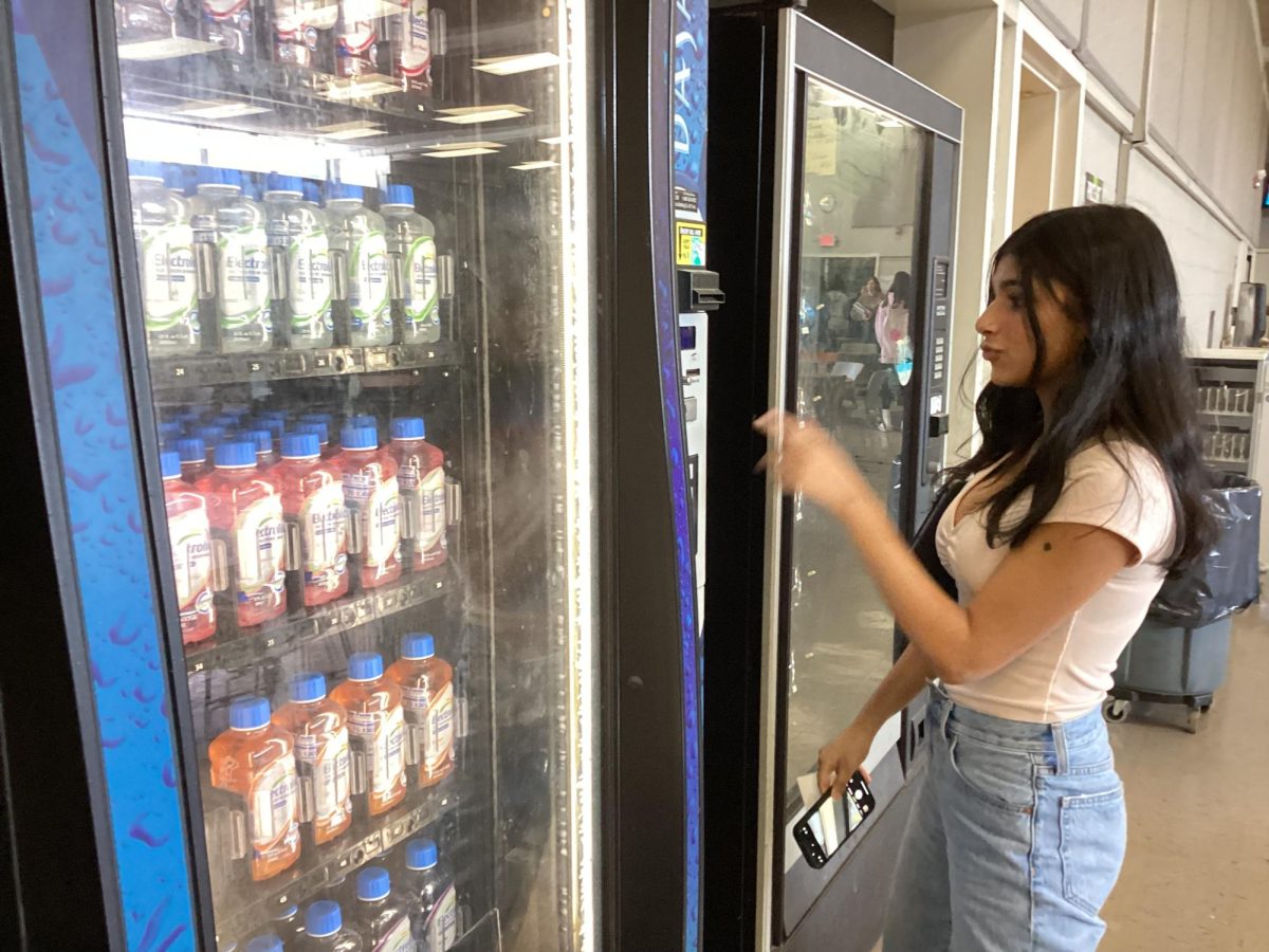 Student gets a drink from the vending machine. 